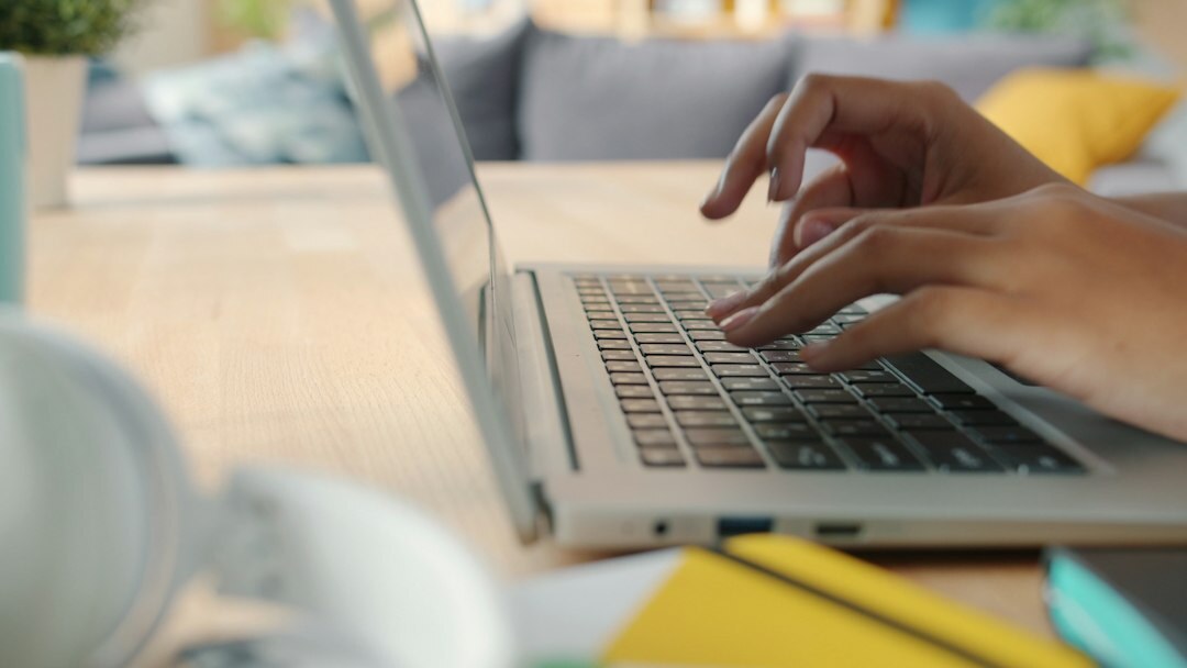 person scrolling on laptop at home